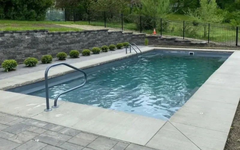 concrete pool deck with stamped concrete patio and elaborate retaining wall